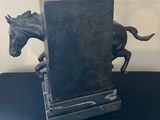 a statue of a horse running on a black table