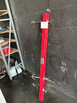 a red pipe sticking out of a wall next to a ladder