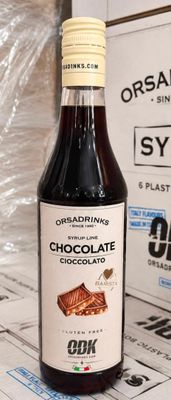 une bouteille de sirop au chocolat à côté d'une boîte de chocolats