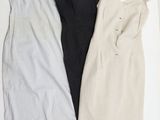 trois robes sont disposées sur une surface blanche