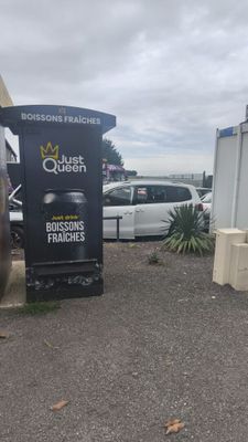 cars parked in a parking lot next to a building with a sign on the side of it