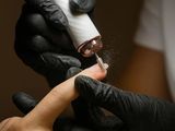une personne qui se fait poser du vernis à ongles