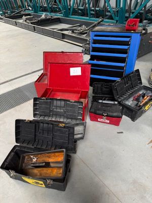 de nombreux outils différents dans la boîte posée par terre