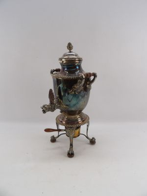 a silver and blue vase on a stand on a white background