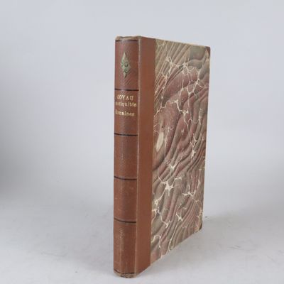 un vieux livre posé sur une table blanche à côté d'un mur blanc