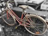 a red bicycle that is hanging from a wire