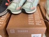 several pairs of running shoes sitting on top of boxes in a store