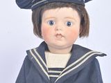a small doll that is dressed in a sailor ' s outfit