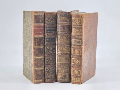 three old books sitting on top of each other on a white surface