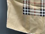 beige and black plaid tote bag hanging on a blue wall