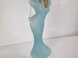 a blue glass vase with a gold leaf on top of it