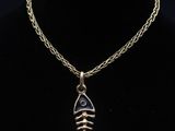 un collier en or avec un pendentif en forme d'arête de poisson sur un mannequin noir