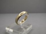 une photo d'une bague en or posée sur un socle transparent