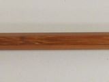 a wooden stick with a metal handle on a white surface
