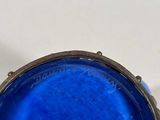 a close up of a blue glass bowl on a white surface