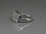 sterling silver ring with blue topaz and diamonds on a reflective surface