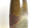 a brown and green vase sitting on a white surface