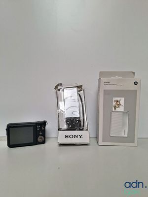 un appareil photo Sony à côté d'un téléphone Sony dans une boîte