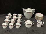 de nombreuses tasses et soucoupes, ainsi qu'un pichet, sur la table