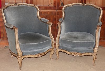 une paire de fauteuils en velours bleu dans une pièce aux murs lambrissés