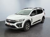 La voiture blanche est garée dans une pièce au sol noir.
