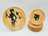 des assiettes en bois ornées d'une image représentant une femme et des oiseaux