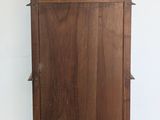 a wooden cabinet with a shelf on top of it