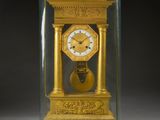 une horloge dans une vitrine posée sur une table avec un fond noir