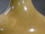 a yellow vase that is sitting on a table