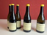 quatre bouteilles de vin sont alignées sur une table