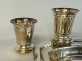 a silver plate and a silver cup on a table