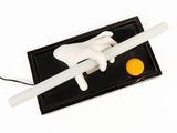 a white toothbrush sitting on top of a black tray with an egg