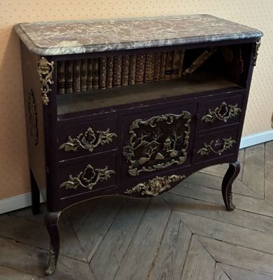 un meuble violet avec un plateau en marbre et une étagère à livres