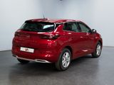 the rear end of a red car in a showroom