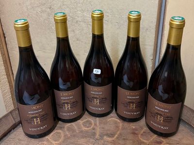 six bouteilles de vin sont alignées sur une table en bois