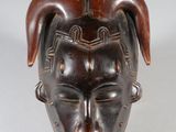 an image of a wooden mask with horns on it ' s head