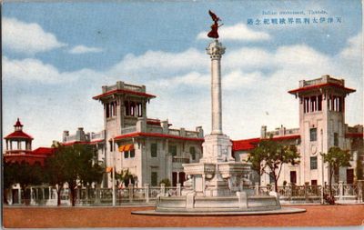une carte postale représentant un bâtiment avec une fontaine devant