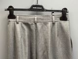 un pantalon gris suspendu à un cintre dans une pièce blanche