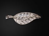 une broche en feuille d'argent sertie de diamants sur fond noir