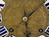a gold clock with blue and white stripes on it