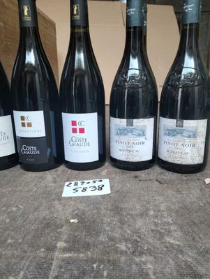 six bottles of wine are lined up on a table with a price tag