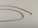 a close up of a silver chain on a white surface