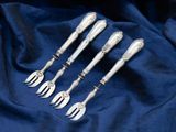 a set of five silverplated forks and spoons on a blue cloth