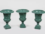 three green vases sitting next to each other on a white surface