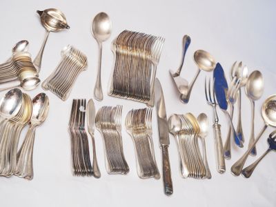 beaucoup d'argenterie sur une table avec des cuillères et des fourchettes