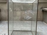 une boîte en verre posée par terre devant un immeuble