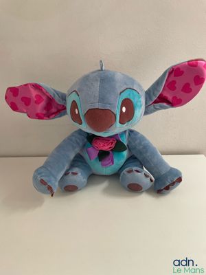 disney lilo plush toy sitting on a white surface with a pink bow tie