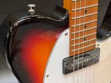 an orange and white electric guitar sitting on top of a black table