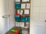 a room with a desk and a shelf with boxes on it