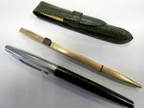 two pens and a pen case sitting on a table